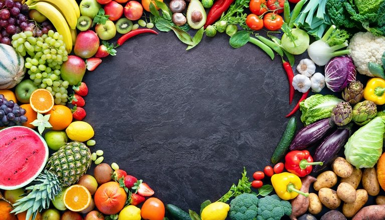 Obst und Gemüse um ein schwarzes Herz in der Mitte angeordnet 